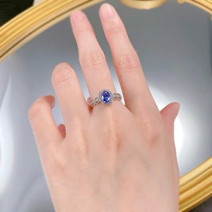 Macro shot of oval blue sapphire halo ring with intricate openwork silver band details