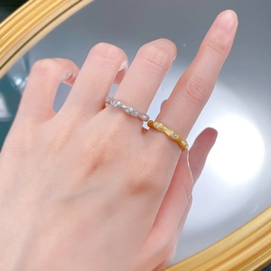 Close-up of hand-crafted bamboo style silver and gold rings with sparkling small diamonds