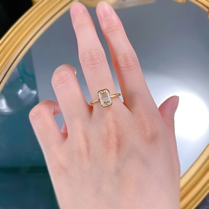 Dettaglio di un anello dorato con cristallo rettangolare taglio radiant sul dito