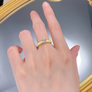 Close-up of S925 silver gold-plated ribbon ring with brushed texture and white diamond