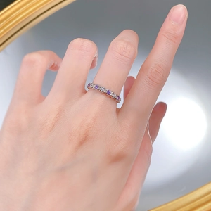 Vue macro d'une bague en argent S925 avec zircons violets et blancs alternés