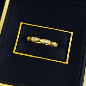 Macro shot of S925 gilded bamboo ring with brushed texture and three inset gemstones