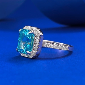 Emerald cut blue gemstone ring with double halo white diamonds on silver band