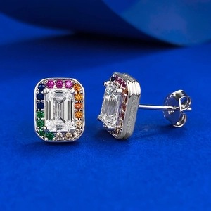 Macro shot of 925 silver stud earrings with emerald-cut center stone and rainbow halo