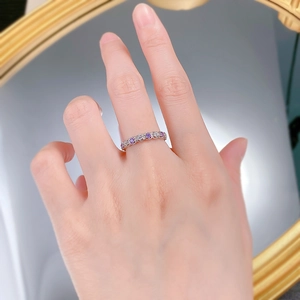 Gros plan d'une bague en argent S925 avec zircons violets et blancs sur un doigt