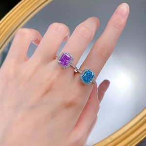 Close-up of purple and blue high carbon diamond rings with halo setting on hand