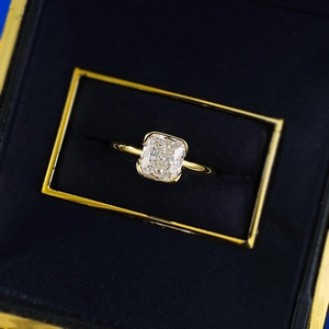 Macro detail of rectangle-cut diamond ring with bezel setting in a velvet box