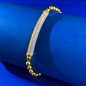 Macro shot of gold-plated beaded bracelet with micro-pave diamond tube detail