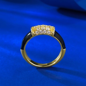Détail d'une bague vintage dorée avec émail noir et pavage de zircons clairs