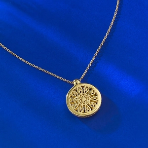 Macro shot of 18K gold plated S925 silver mandala hollow pendant necklace on blue background