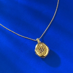 Detail of vintage gold-plated S925 silver necklace with red garnet filigree pendant