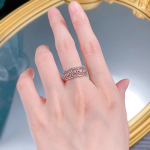 Close-up of vintage lace silver ring with rose gold finish and red stone detailing