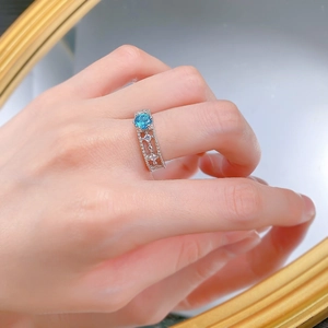 Vue détaillée d'une bague en argent S925 avec saphir bleu et anneau floral ajouré