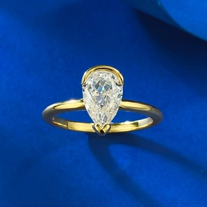 Detailed macro shot of pear-cut white diamond ring with gold minimalist band