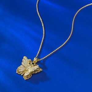 Gros plan du pendentif papillon doré avec cristaux scintillants sur bleu