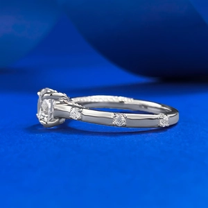 Klassischer Silber-Verlobungsring mit brillantem Solitär auf blauem Seidenhintergrund