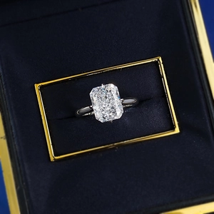 Detail of luxury emerald cut silver ring with sparkling stone in navy blue jewelry box