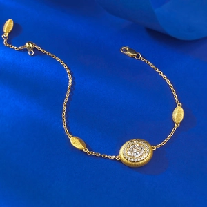 Détail macro d'un bracelet en argent S925 doré avec pierre ovale et perles dorées brossées