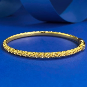 Bracelet jonc tressé en argent 925 plaqué or élégant sur fond bleu profond