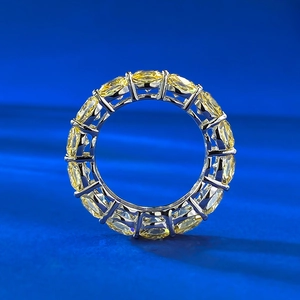 Macro shot of silver eternity ring featuring vibrant yellow cushion-cut gemstones