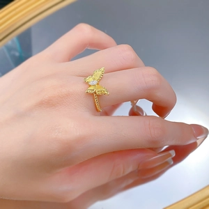 Detail of gold butterfly ring featuring brushed texture and marquise cut zircon stone