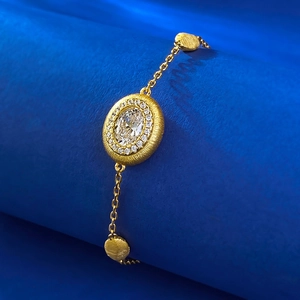 Bracelet vintage en argent S925 doré avec grande pierre ovale sur un socle de présentation bleu