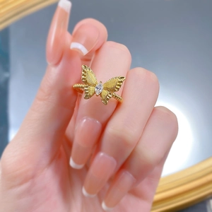 Detailed close-up of a gold butterfly ring with textured wings and marquise gemstone