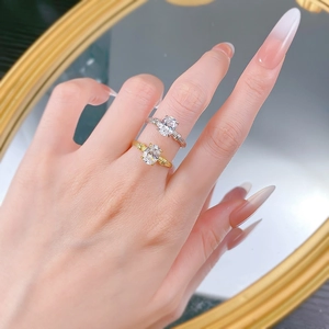 Macro detail of oval cut gemstone rings in silver and gold finish worn on a finger