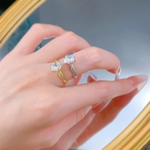 Detail of silver and gold plated oval moissanite rings with twisted rope band on hand
