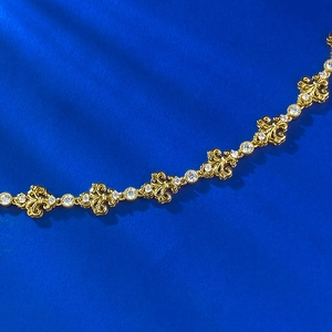 Exquisite gold iris fleur-de-lis bracelet with sparkling white gems on blue background