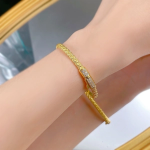 Gros plan du bracelet tressé en argent doré avec fermoir en zircone brillant au poignet