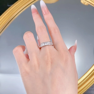 Gros plan d'une bague éternité en argent S925 taille princesse sur doigt avec reflet