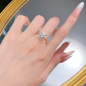 Close-up of classic 10mm round cut solitaire ring with four-prong setting on hand