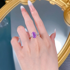 Detailed view of an oval purple high-carbon diamond ring on a model hand with silver band