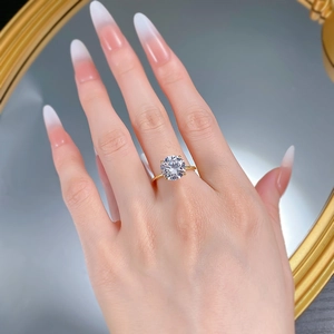 Macro detail of 10mm round solitaire diamond ring with four-prong setting on hand