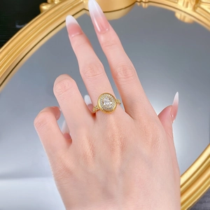Macro détaillée d'une bague halo S925 avec texture dorée brossée sur un miroir