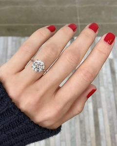 Close-up of a 10mm round cut sparkling solitaire diamond ring with a classic six-prong setting