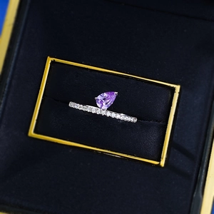 Close-up of S925 silver ring with a pear-shaped purple gemstone in a black jewelry box
