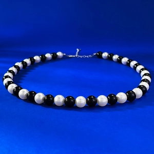 French vintage necklace with 8mm round pearls and black agate beads on blue background