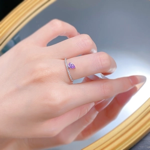 Close-up of S925 silver ring featuring pear-cut purple zircon and pavé-set band on finger