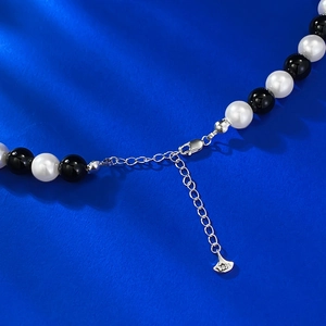 Macro shot of S925 sterling silver lobster clasp and extension chain on pearl necklace