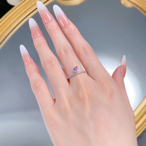 Detail of S925 silver ring featuring a pear-shaped purple gemstone on a finger