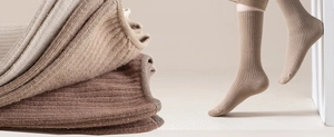 Close-up of ribbed knit crew socks in earthy tones showing texture and fit on foot