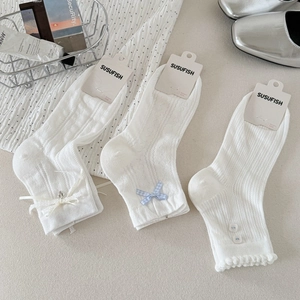 Détails de chaussettes blanches en maille avec nœuds en dentelle et boutons décoratifs