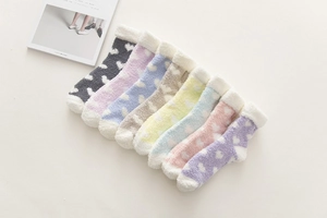 Close-up of thick coral fleece heart pattern socks in multiple pastel colors with fluffy cuffs