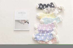 Flat lay of warm coral fleece socks with heart patterns and plush cuffs in eight colors