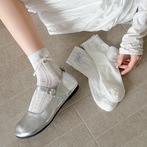 Détail de chaussettes résille blanches avec bordure dentelle et nœuds en soie élégants