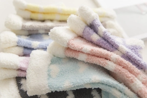 Close-up of thick coral fleece socks in pastel colors with soft cloud patterns