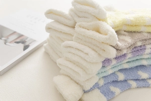 Macro detail of fluffy coral fleece winter socks in assorted soft pastel candy colors
