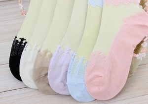 Detailed set of women's sheer lace socks in six pastel colors on a wooden background